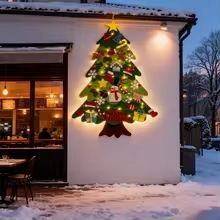 Sapin de Noël mural en feutrine présenté sur un mur extérieur enneigé